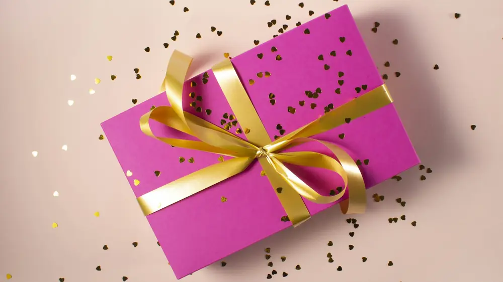 Kado bonus dengan koin emas di atas meja kayu